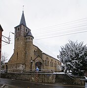 Religious building in stone in Neo-Romanesque style under snow.