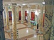 The entrance hall preserves the marble Ionic columns and tile mosaic floors of the original, 1896 Eidlitz design.