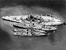 Overhead view of a large warship with three smaller warships tied alongside