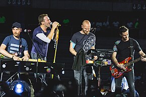 Coldplay onstage with their respective instruments