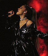 Ariana Grande performing and holding a mic in her hand.