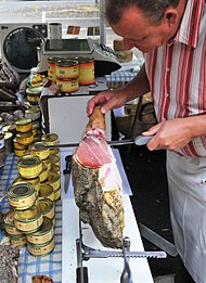 Découpe d'un jambon dans une charcuterie de Dax