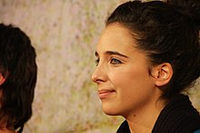 Profile photo of a smiling young woman with brown hair in an up-do