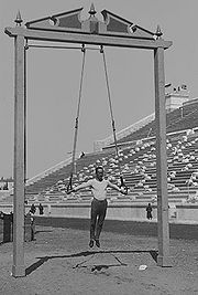 Der ehemalige deutsche Turner und Olympiasieger Hermann Weingärtner zeigt bei den Olympischen Spielen 1896 an einem im Freien stehenden Ringegerüst einen Kreuzhang.