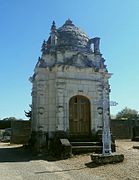 Photographie en couleurs d'une chapelle en pierre surmontée d'un dôme à écailles.