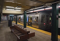 The underground Court Square station is the "G" train's northern terminus. There are two tracks in the station, one on each side of the center platform, with a "G" train on the right-hand track.