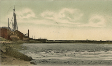 A wave rolls by in the foreground, while a boat sits to the left of the background.