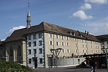 Photo de l'emplacement où se trouvait la Tour Jacquemert à Fribourg en 2011. On distingue le corps du bâtiment du couvent des Ursulines surmonté d'un petit clocher avec une croix. Le couvent des Ursulines est situé , 2 rue des Alpes à Fribourg, et à côté de ce bâtiment se trouvait la tour de Jacquemart, démolie en 1853. dans cette tour furent emprisonnées des personnes accusées de sorcellerie, dont le dénommé Bouquet, dénoncé par Catherine Repond. Des sorcières y auraient subi le supplice du quintal