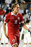 Felix Michel Melki wearing a red Lebanon shirt with white collar and details