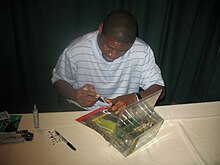 Bennett autographing memorabilia at a table