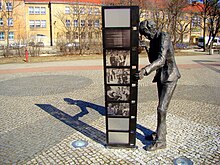 Komeda-Skulptur in Poznań (Posen), Szenen aus Filmen mit seiner Musik betrachtend, heute vor dem Kongress- und Lehrzentrum der Medizinischen Universität