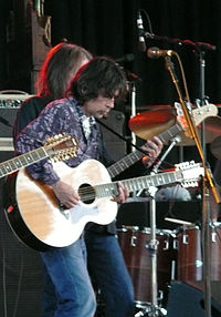 Anthony Crawford, playing an acoustic guitar while on a stage.