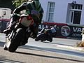 Racing motorcyclists cornering at the site of a former pub.