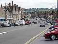 The wide main street of Chipping Sodbury. Cars are parked where market stalls would once have been.