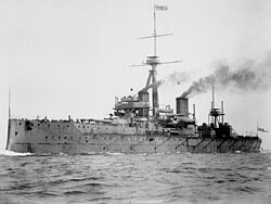 Ship at sea with smoke emitting from two funnels