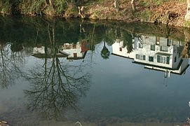 Photographie du reflet d’une maison dans un plan d’eau.