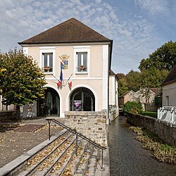 The town hall and river Orvanne in Voulx