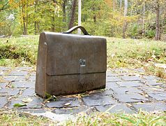 Wallenberg's briefcase in bronze, with the initials R W, set up on the doorstep to the summer house at Kappsta, Lidingö, where Wallenberg was born.It is at 59.340862 N, 18.166985 E. The setts come from Budapest.