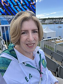 Headshot of Creagh in a white and green jacket