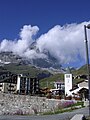 L'église de Notre-Dame Reine de la Vallée d'Aoste (en latin, Regina vallis augustanæ). À l'arrière-plan, le Cervin dans les nuages.