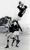 John Coleman of Essendon takes a spectacular mark over North Melbourne full-back Vic Lawrence in 1953.