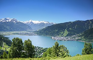 rechts Zeller Altstadt, links Zell am See-Süd, vorne Thumersbach; vom Mitterberg, Richtung Südwesten über Zeller See gegen Hausberg Schmittenhöhe, und über Salzachtal gegen Kitzsteinhorn