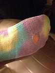 Sock with a hole in it, through which the foot is visible.