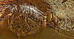 Interior of a cave with dripstone formations and a walking path