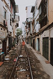 A track runs down the middle of a narrow street, taking up half its width