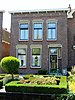 Halfvrijstaand woonhuis op rechthoekige plattegrond. Hoofdbouw met rechte lijstgevel, waarachter begane grond en dakverdieping met zadeldak. Woningtoegang in terugliggend recht portiek. Voorstoep in granito.