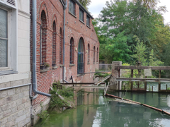 Photographie d'un château au fond de champs ouverts.