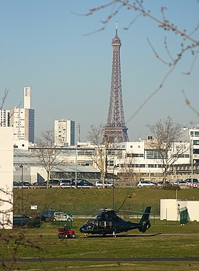 SA365 Dauphin sur l'héliport d'Issy avec la tour Eiffel et le Front de Seine en arrière-plan.