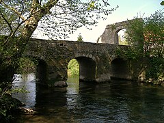 Photographie montrant un pont de pierres à trois arches enjambant un cours d'eau.