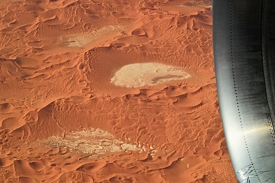 Aerial view of pastel-colored sand dunes in the Sahara desert, Erg Tiffernine, Algeria