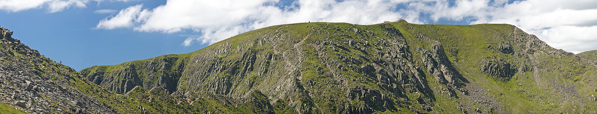 Golok panorama a Helvellyn, gans Striding Edge a-gledh, an leder serth dhe'n topp, keyn an topp, ha'n diyskynnans dhe Swirral Edge a-dhyghow