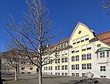 Schulhaus Hans Asper, rechte untere Ecke: Skulptur Verwandlung von Johannes Peter Staub, 1974–1975