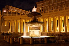 View of one fountain which rises in two tiers from a sculptured pool. The fountain is playing and the water is sparkling.