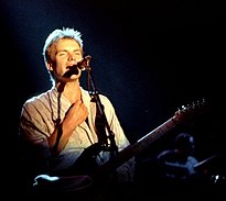 A man holding a guitar and singing into a microphone