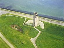 Aerial photograph of a white stone tower near the shore