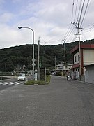 日鉱小志生木駅跡付近 トンネルがやや海に向かっているが、当時の海岸線は現在よりも山寄りで、駅も旧道沿いにあった。道路整備の前までは国鉄バス停留所の前に日鉱幸崎駅跡と同様のプラットホームが存在していたが、消滅してしまった。写真の緑地帯は駅跡を潰した後に設置されたものであり、当時の様子を窺い知ることはできない。