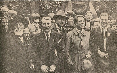 Photographie montrant des hommes posant dos au mur.