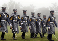 Filipino Cadets marching in the rain wearing greatcoats.