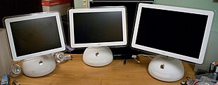 Three white computers arrayed side-by-side; they are identical save for their screens of differing sizes, arranged from smallest to largest.