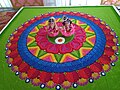 A rangoli is decorated with an idol of Krishna and Radha