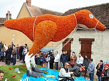 Créature à deux pattes composée de fleurs de couleurs oranges.