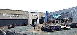 A woman walks toward the mall entrance between the Urban Planet and Old Navy stores