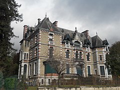 Photographie en couleurs d'un manoir aux murs en moellons chaînés de pierre de taille et brique.