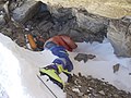 Bilde fra Green Boots Cave - en heller på 8.500 meters høyde. Kroppen i bildet mistet livet i 1996 og har ikke blitt tatt ned fra fjellet per 2019.[94]