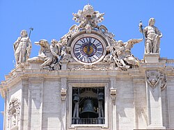 Vue rapprochée de l'horloge et de la cloche, sur la façade gauche de la basilique