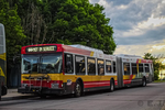 A red, white and yellow articulated bus